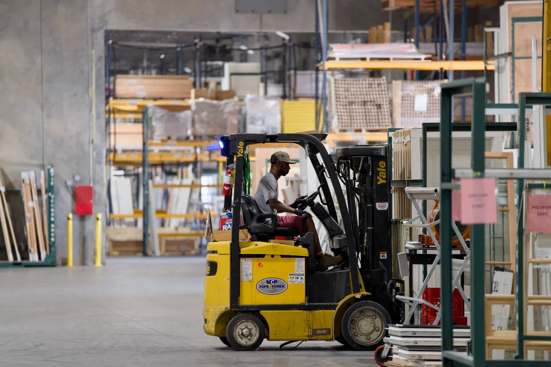 A Tucker forklift operator moving units through the millwork department