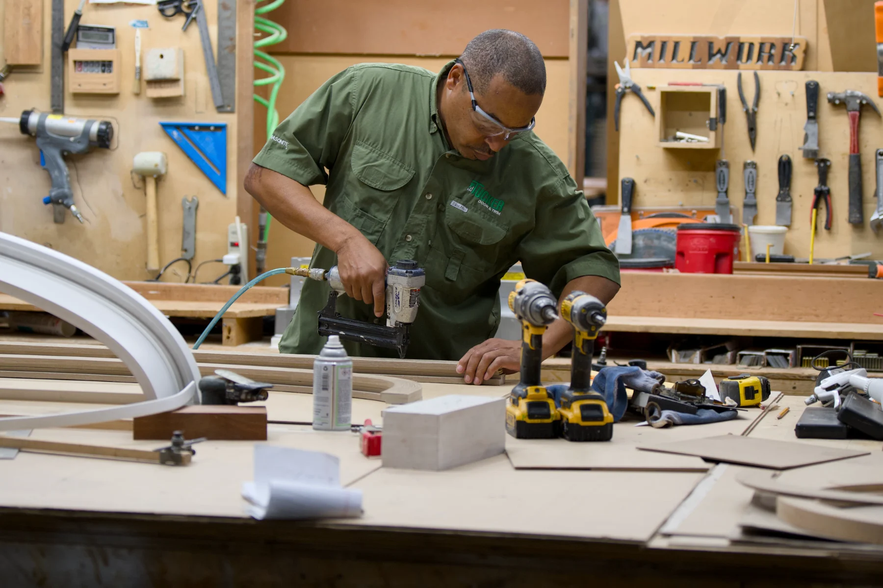A Tucker craftsman nailing a radius trim profile at the millwork bench