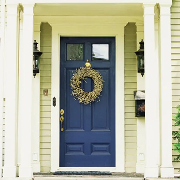 An Intex PVC door surround with a fluted pilaster and crosshead around a blue entry door