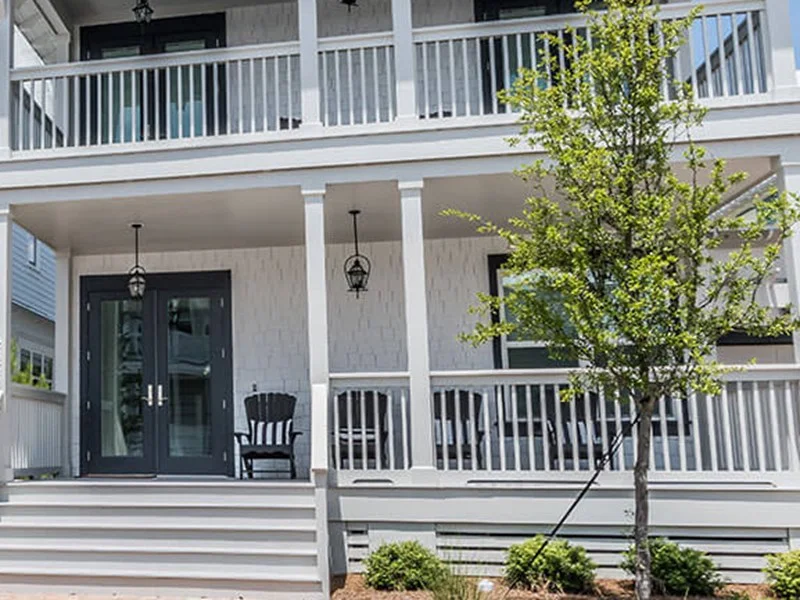 Black Neuma french entry doors on a coastal porch with double balconies