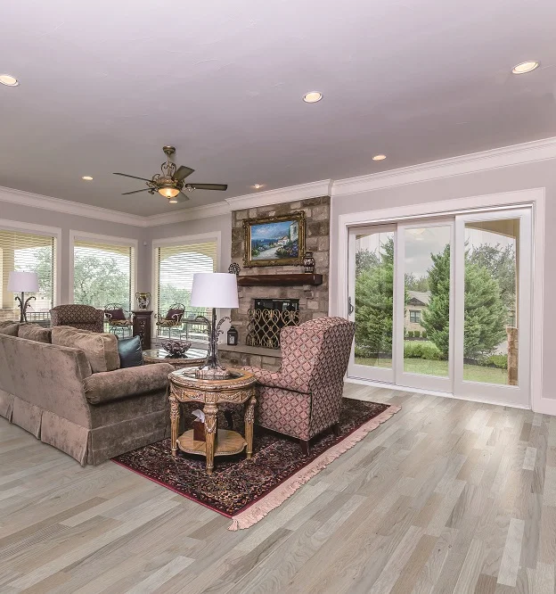 A white Neuma glider in a living room beside a stone fireplace