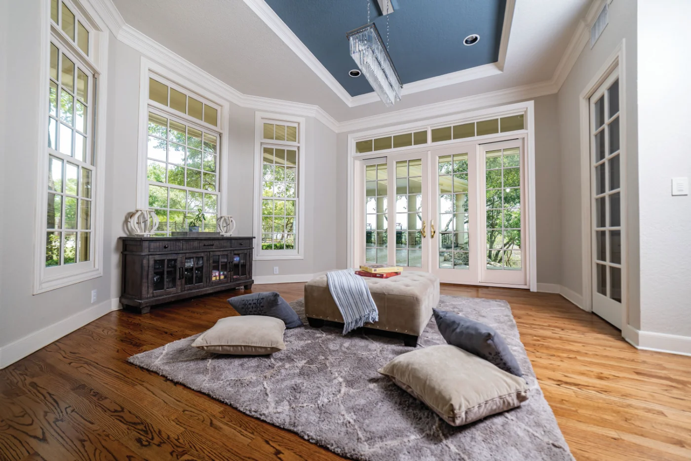A white Neuma glider unit with transom lites in a sunroom
