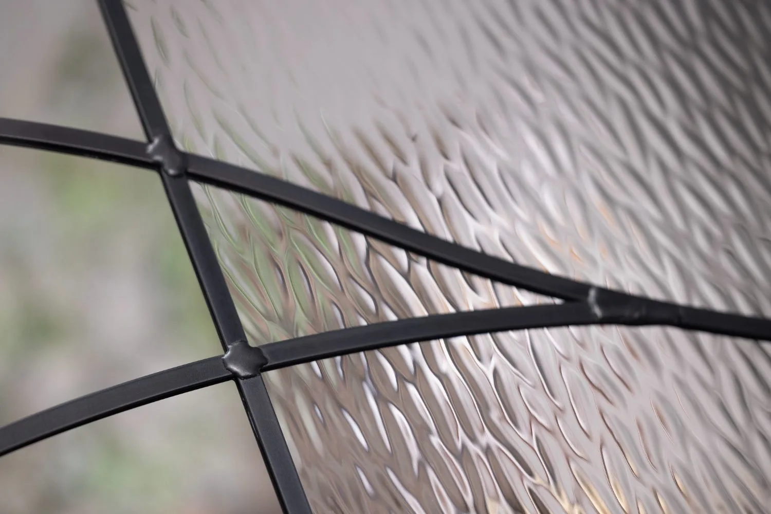 Close-up of ODL Briselle textured glass behind black divided lite bars, showing its rippled leaf-like relief