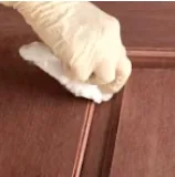 Excess stain wiped off a door panel with a clean cloth
