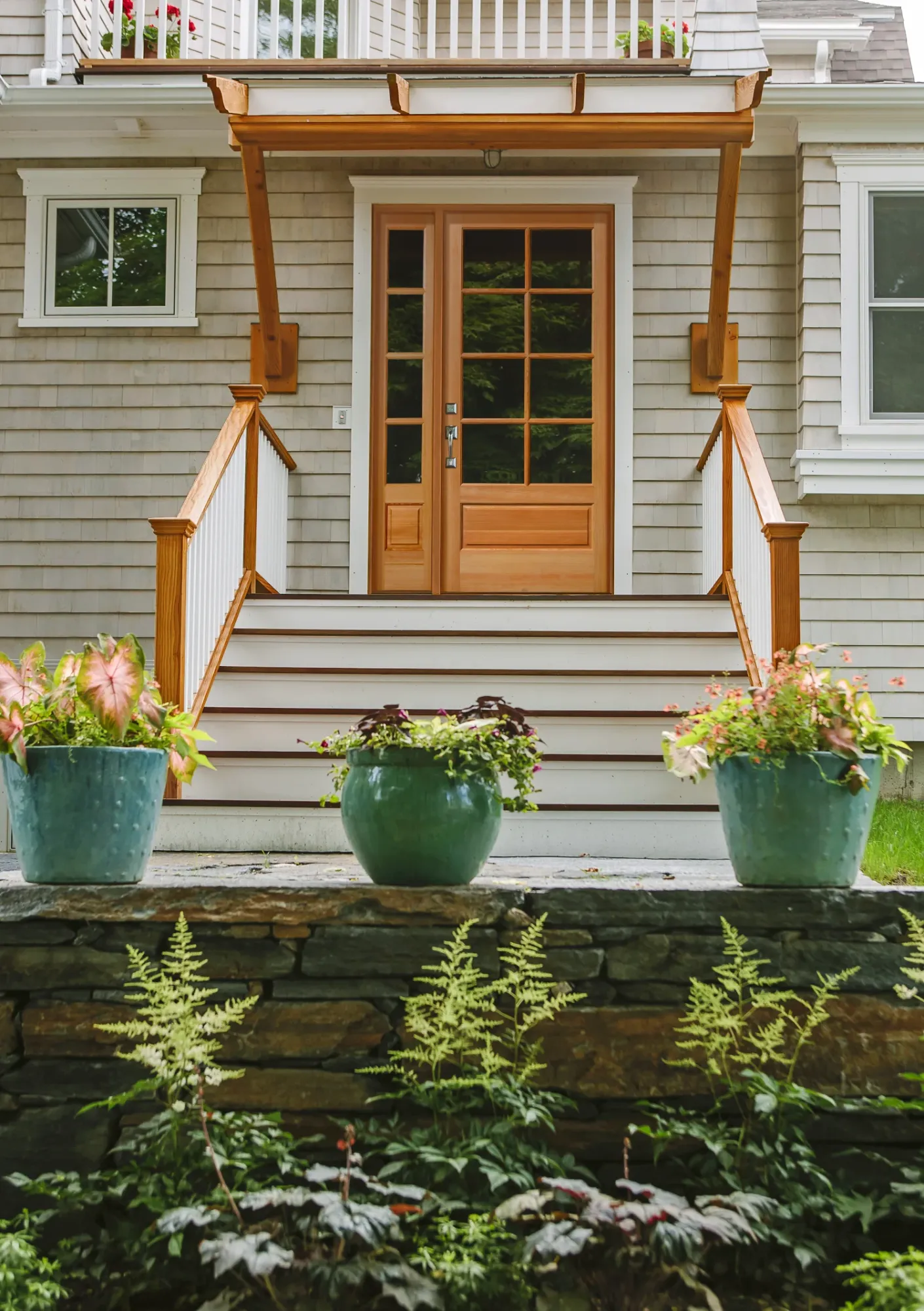 A fir entry door with divided lites and a sidelite under a cedar pergola