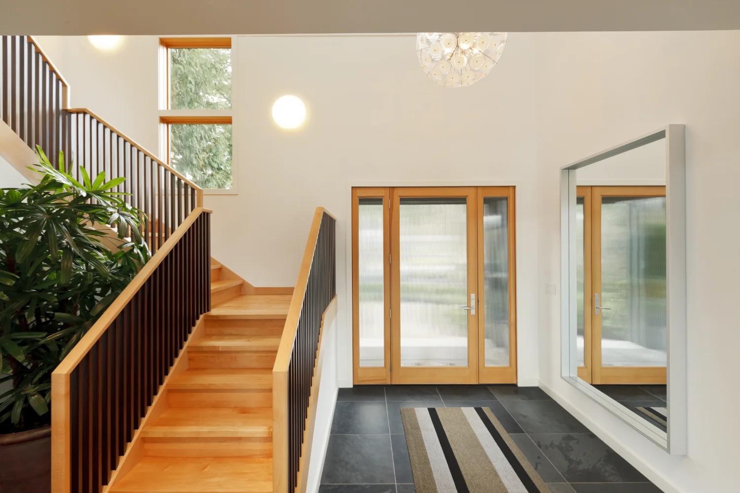 A fir entry door with reeded glass and matching sidelites seen from inside a foyer