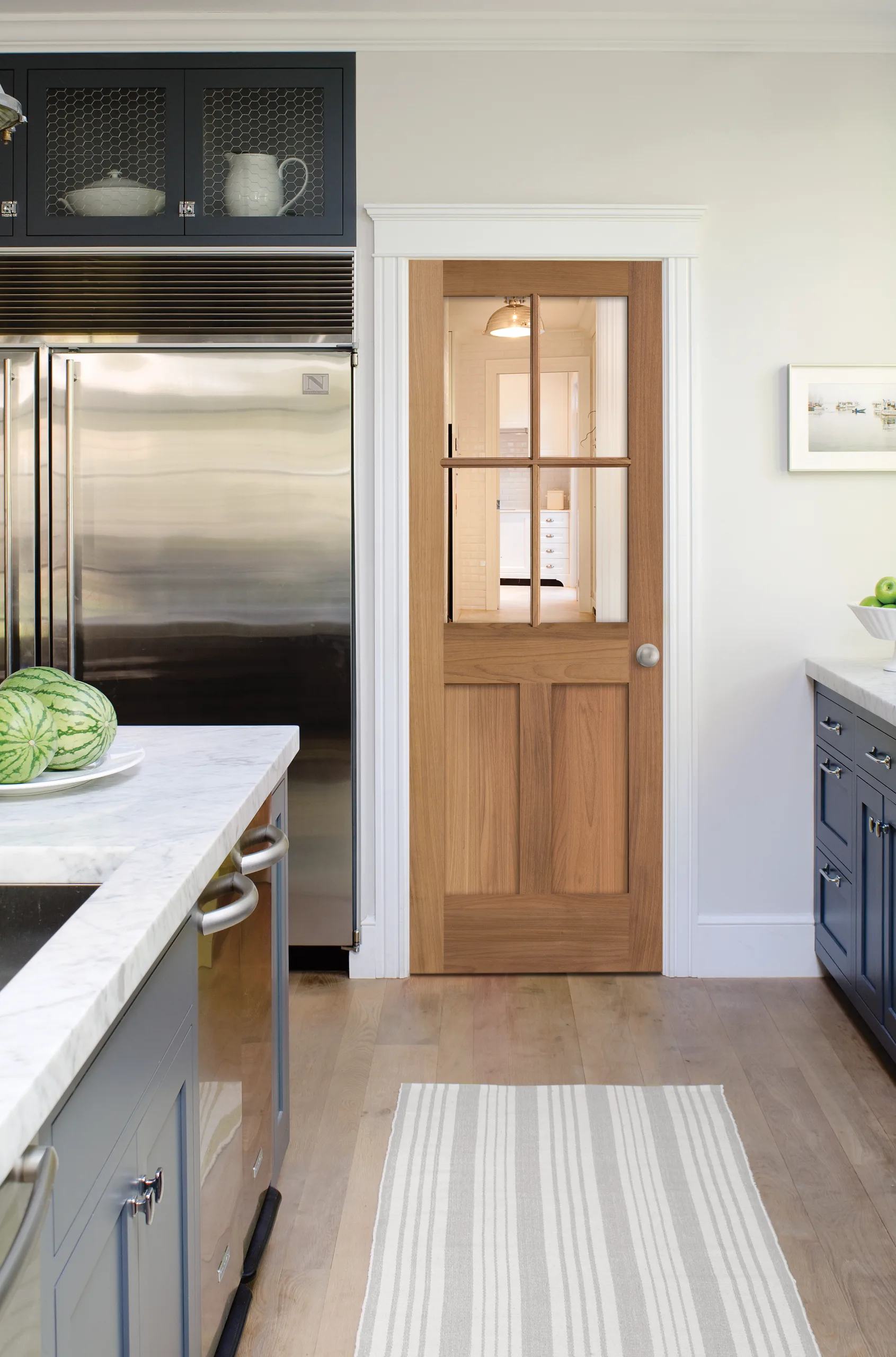 A white oak glazed interior door off a kitchen