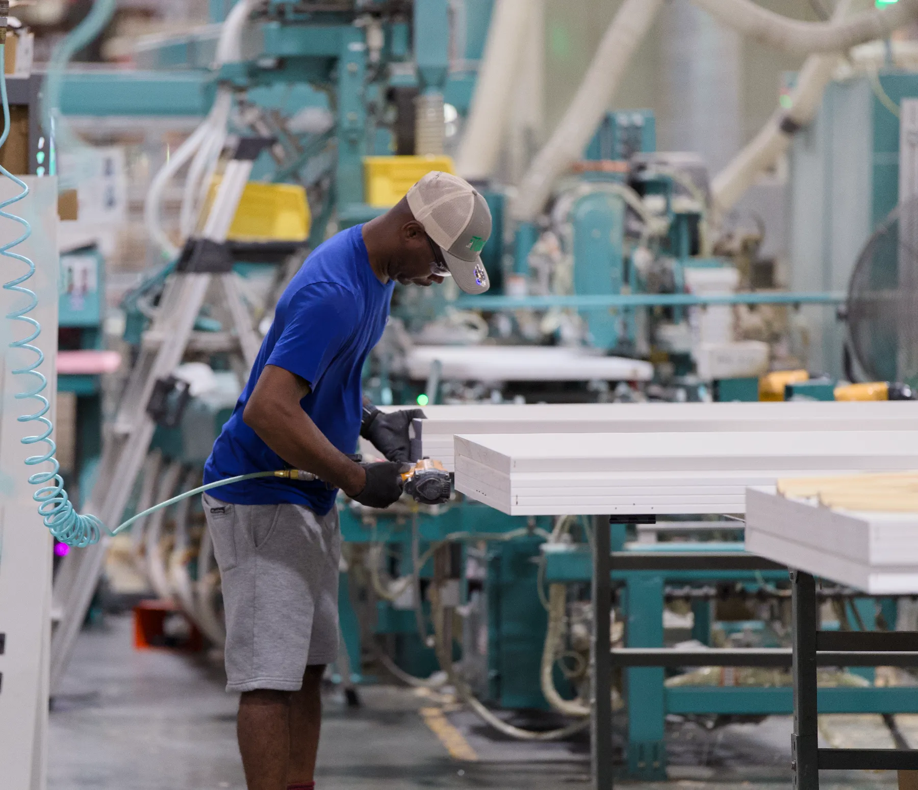 A Tucker craftsman fastening prehung door jambs on the assembly line