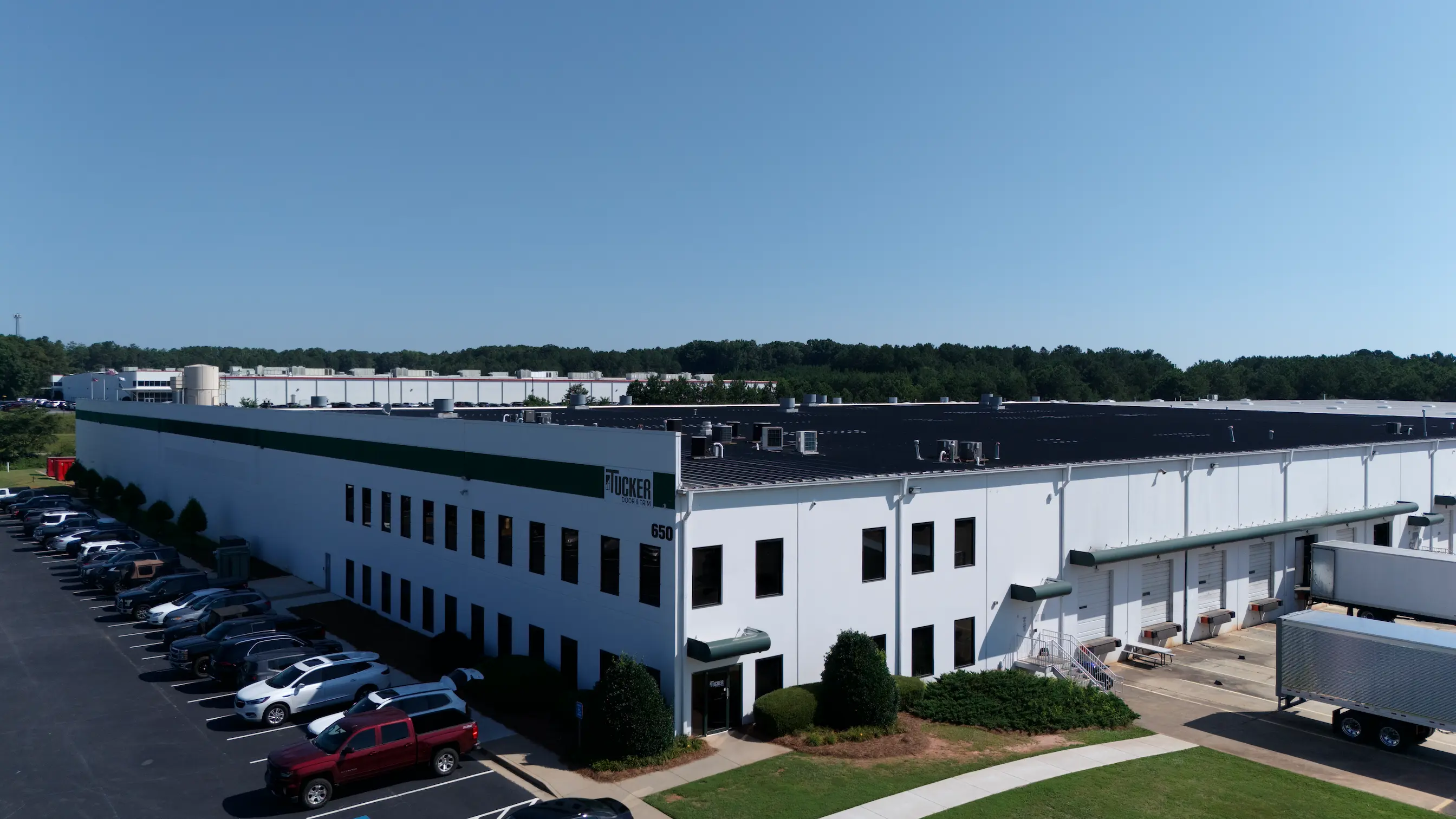 Aerial view of the Tucker Door & Trim plant in Monroe, Georgia, showing the office end, the loading docks, and a trailer at the dock