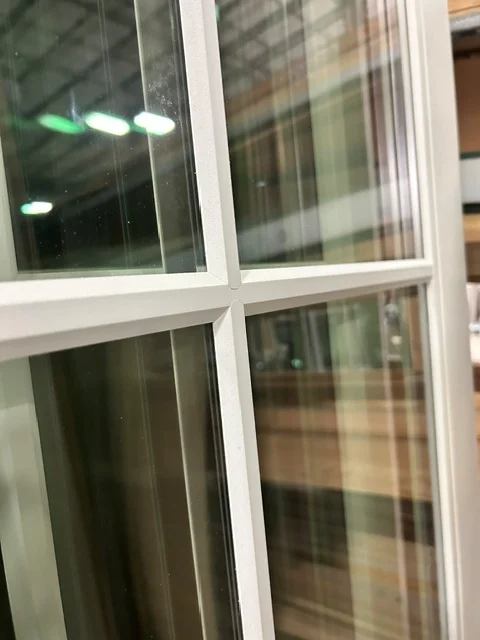 The intersection of horizontal and vertical putty SDL bars on a divided lite door
