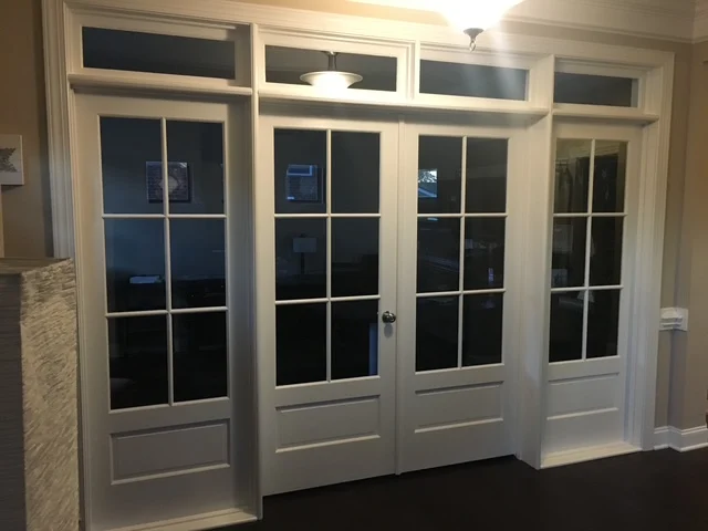 A painted interior SDL double door with sidelites and transoms above