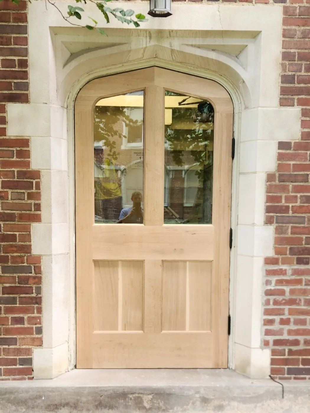 Completed white oak arched entry in the stone opening