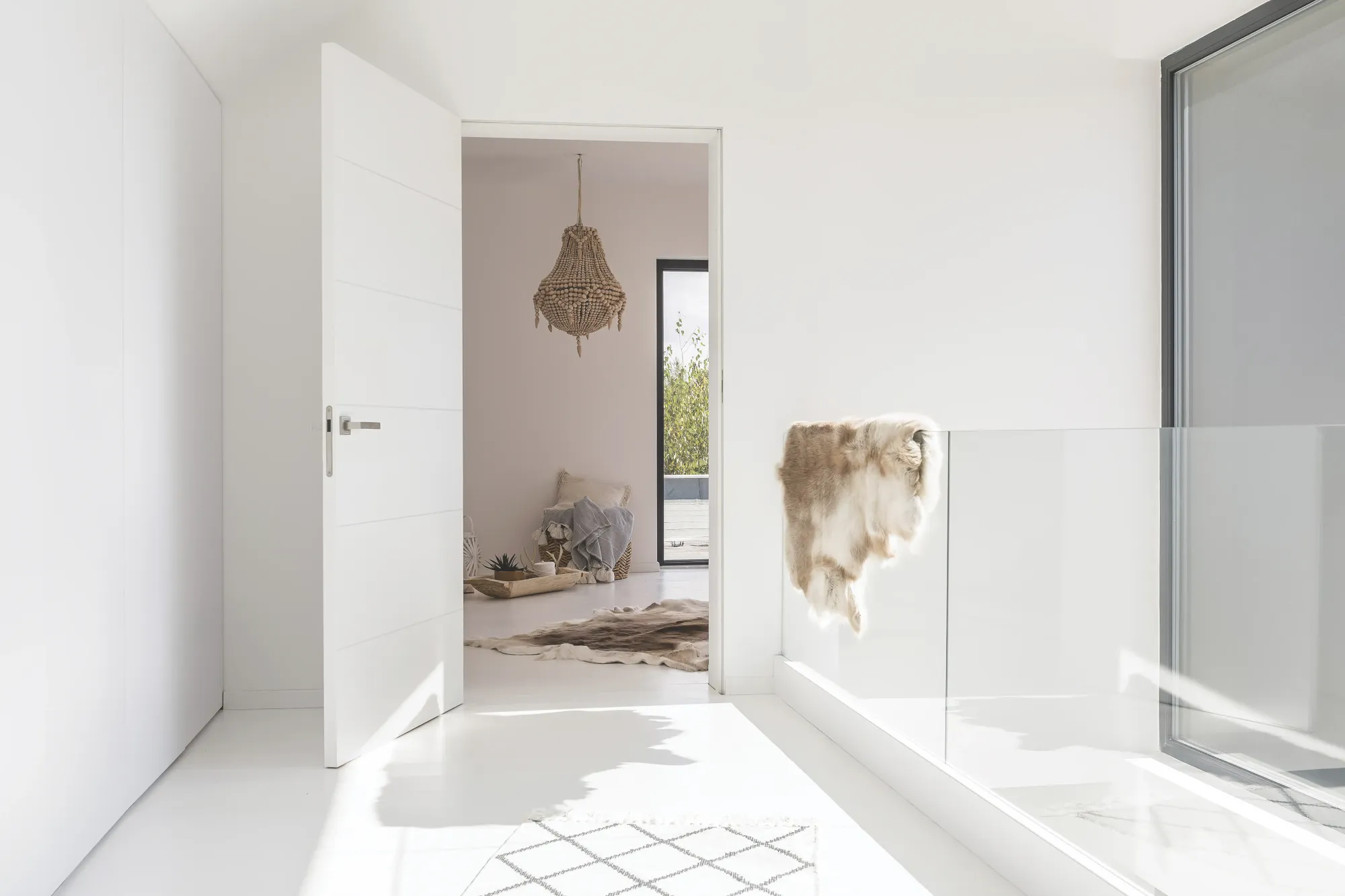 A modern flush panel interior door standing open in a bright white room