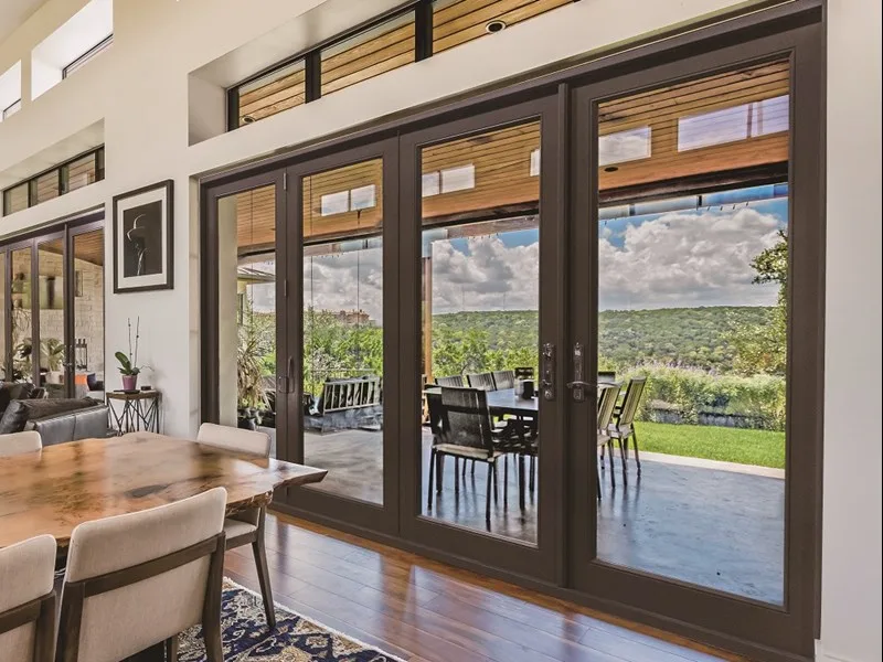 Neuma folding fiberglass patio doors opening from a dining room to a covered patio