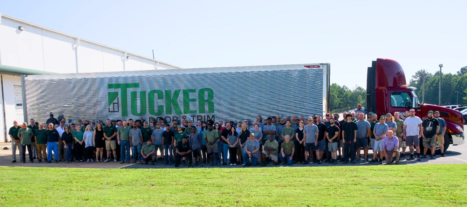 The Tucker Door and Trim crew gathered in front of a company trailer at the Monroe, Georgia plant