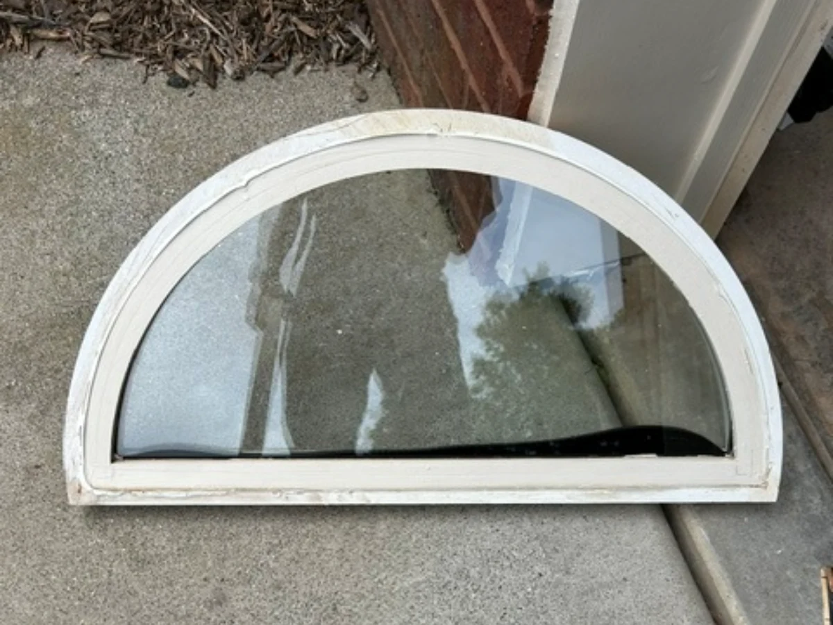 The original half round sash removed and set on the drive