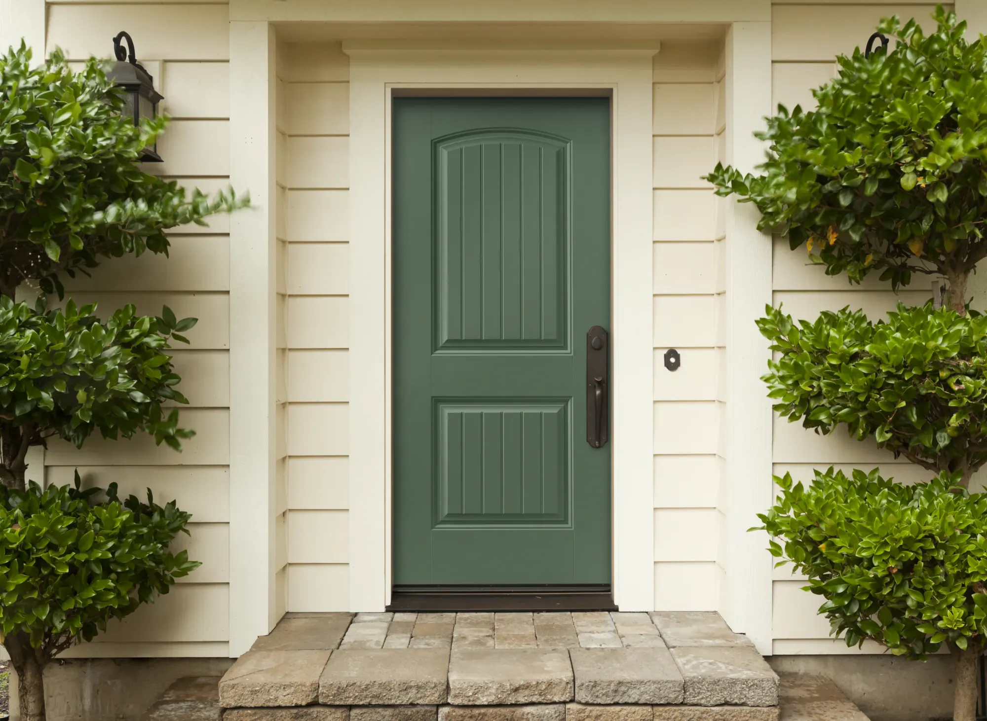 A two panel arch top entry door in kale green