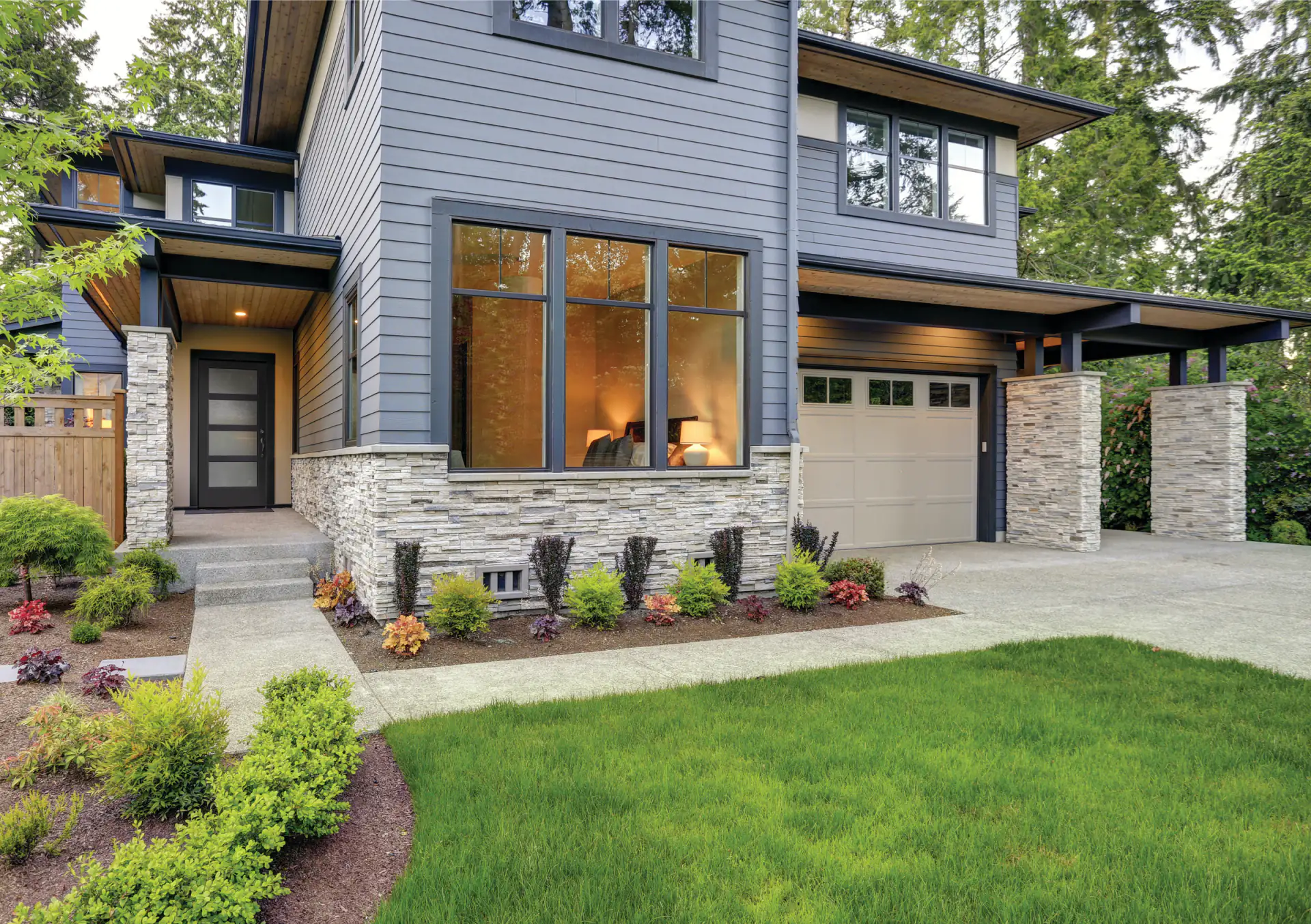 A modern flush entry door in black with a four lite window band