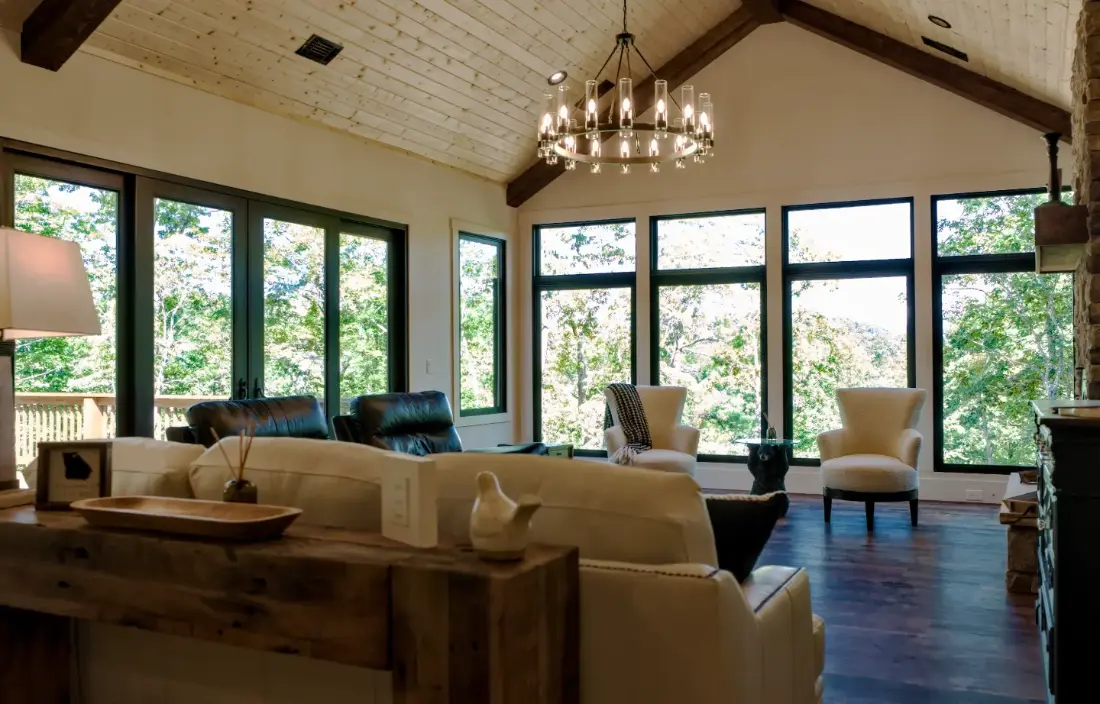 A vaulted great room with a wall of black frame windows and patio doors supplied by Tucker Door and Trim