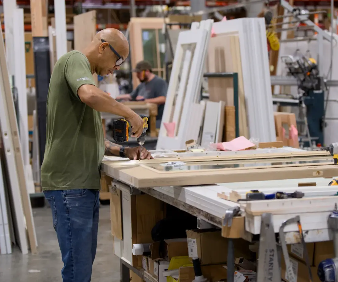 A Tucker millworker driving hardware into a prehung door unit on the shop floor