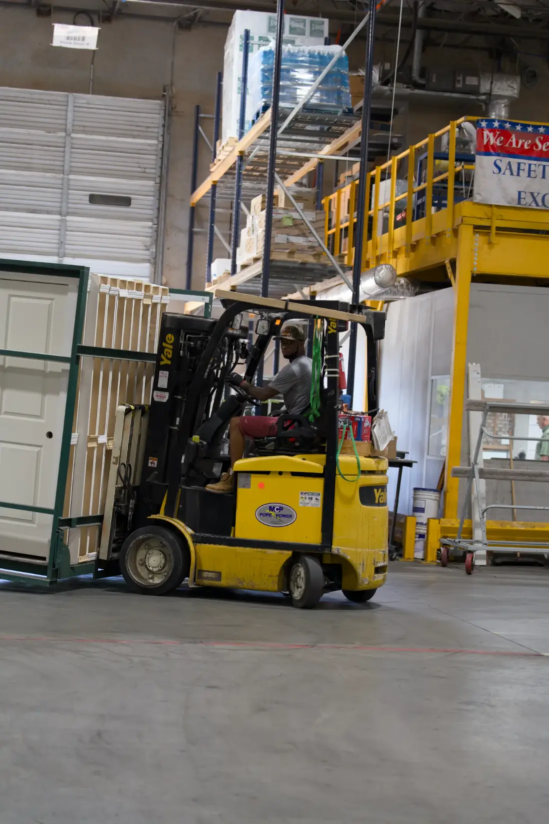 A forklift moving a rack of finished door units across the Tucker warehouse floor