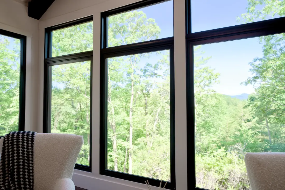 A floor to ceiling wall of Tucker 3300 Series black vinyl windows in a finished great room