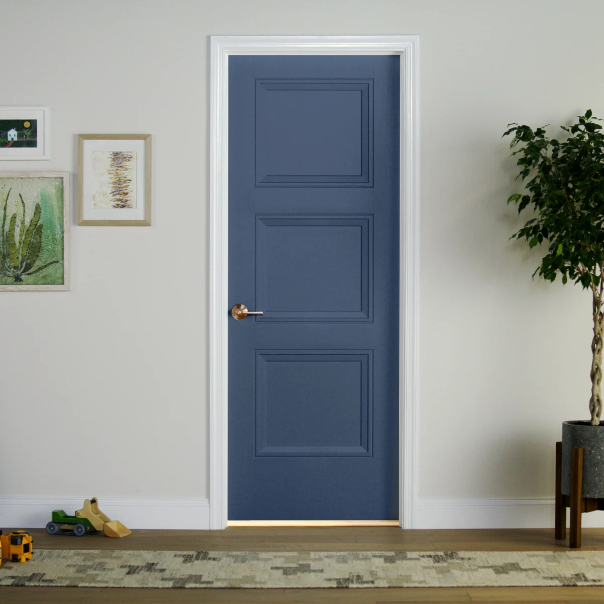 A navy blue three panel interior door hung in a white painted jamb with satin brass hardware